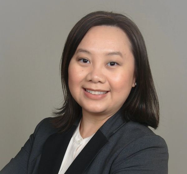 Professional woman smiling, wearing a suit jacket.