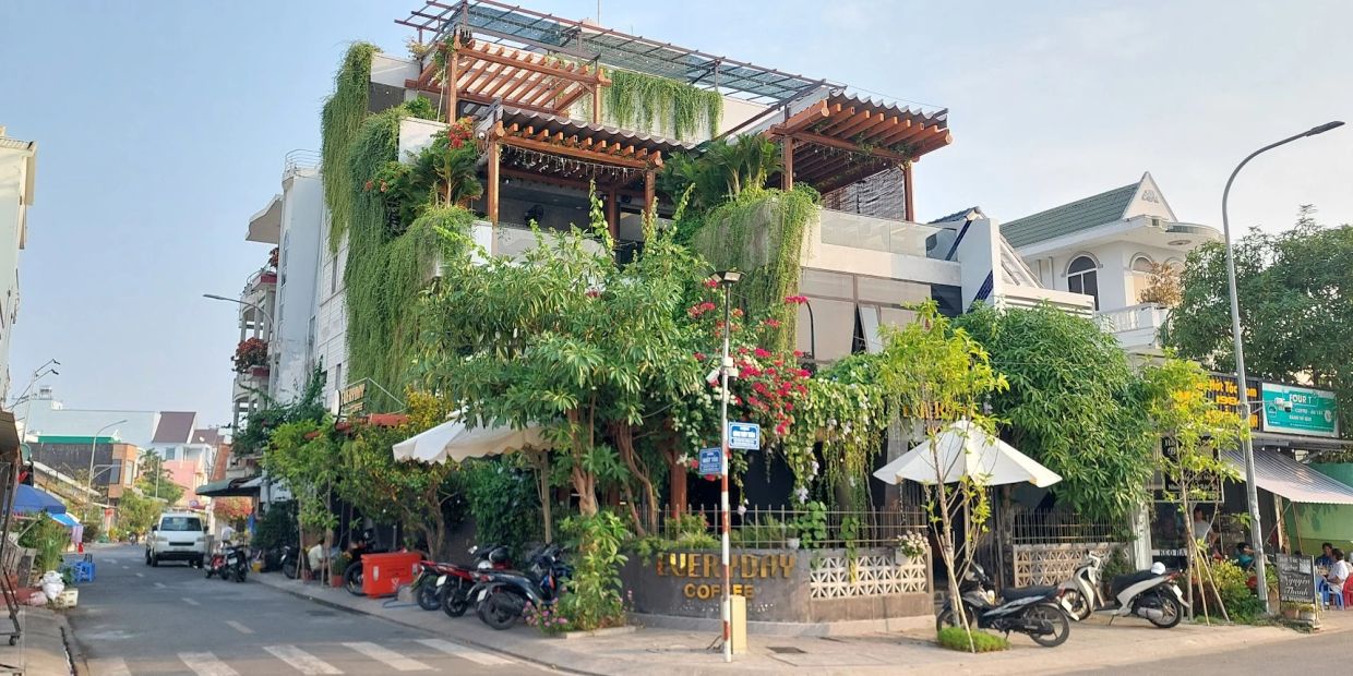 Greenery-covered coffee shop on a street corner.