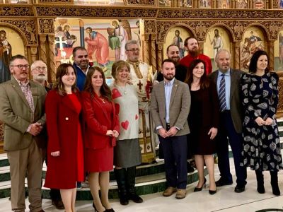 Group photo of people in formal attire inside a church with religious icons.
