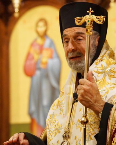 An Orthodox priest holding a staff during a religious ceremony.