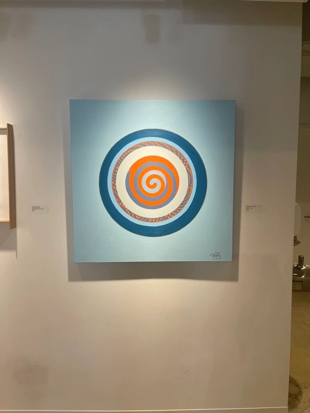 Abstract spiral painting with concentric circles in blue, orange, and white.