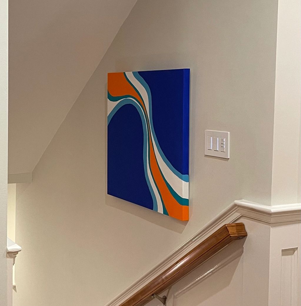Abstract blue, orange, and white painting on a stairwell wall.