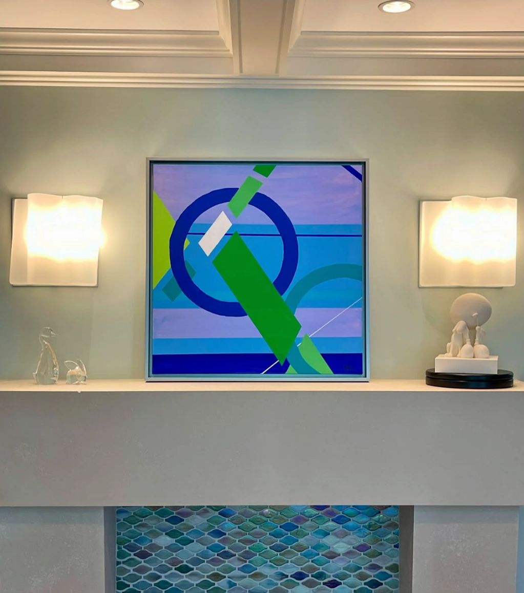 Modern fireplace mantel with abstract art and soft lighting.
