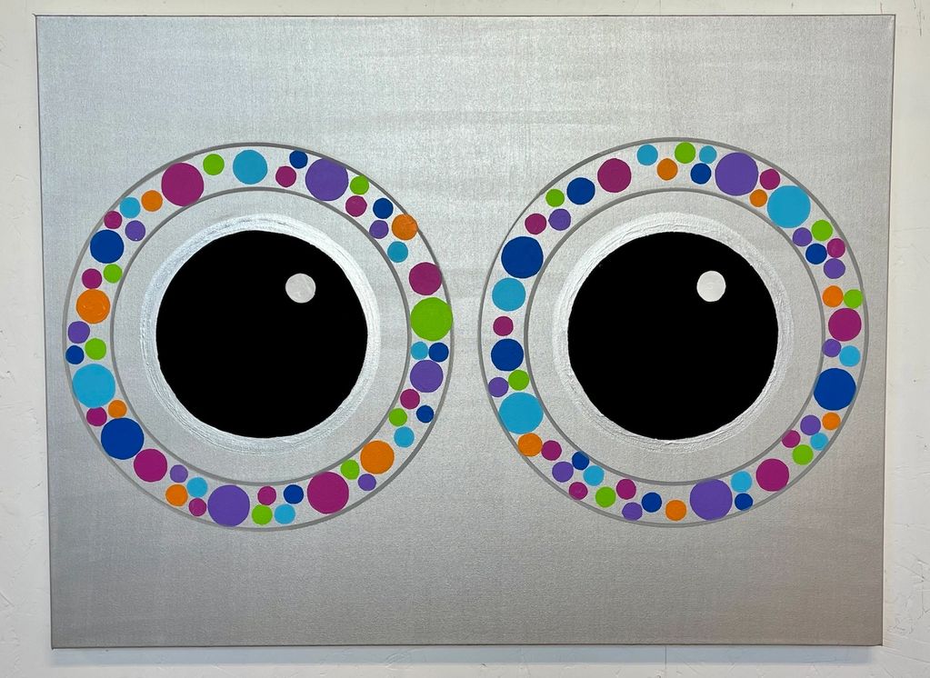 Abstract art featuring two large black circles with colorful dots on a silver background.