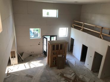 Interior of a house under construction with exposed framing and drywall.