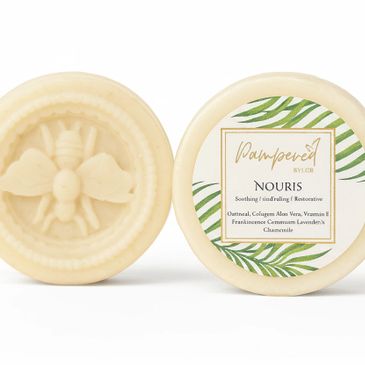 Two round bars of Nouris soap with bee design and natural ingredients label.