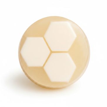 Round soap bar with three white hexagons inside a beige base.
