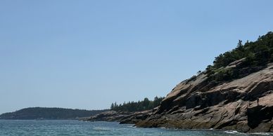 Rocky coastline with clear blue sky and calm sea.
