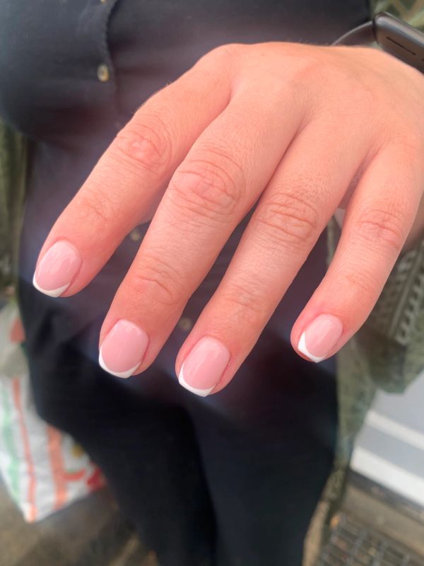Hand with French manicure nails.
