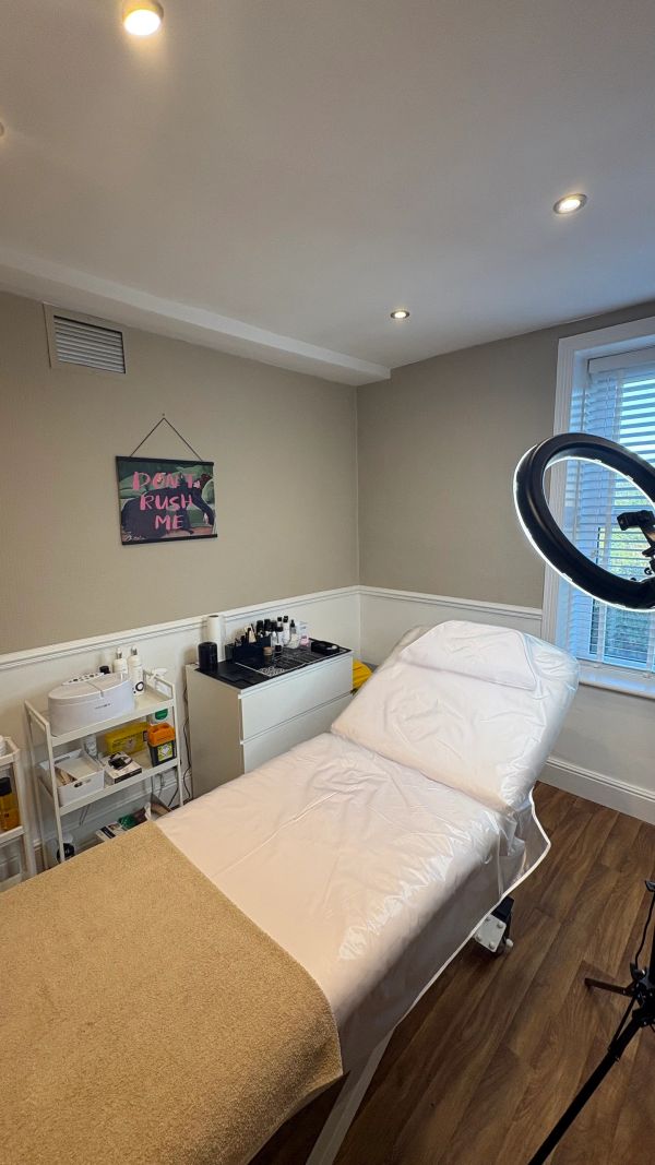A clean, cozy beauty treatment room with a massage bed.