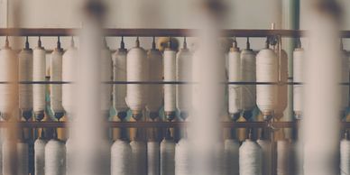 Spools of thread on a rack in a factory.