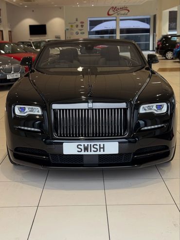 Front view of a sleek black Rolls-Royce with custom license plate 'SWISH'.
