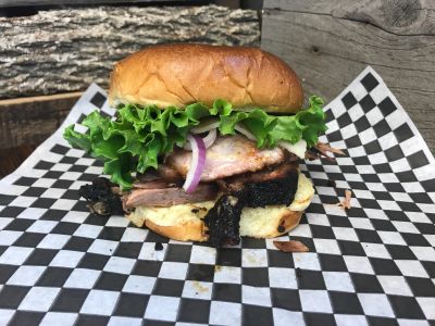 A grilled chicken sandwich with lettuce and onions on a bun.