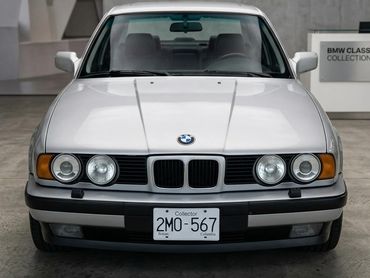 Front view of a classic silver BMW sedan with dual round headlights.