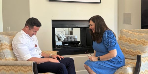 Two people having a conversation in a cozy living room.