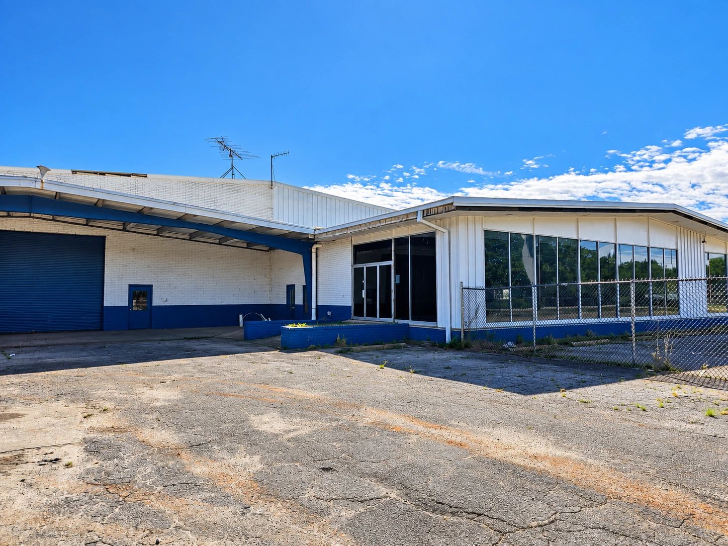 Empty industrial building under clear blue sky.