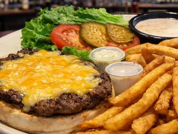 Cheeseburger with fries and fresh vegetables.