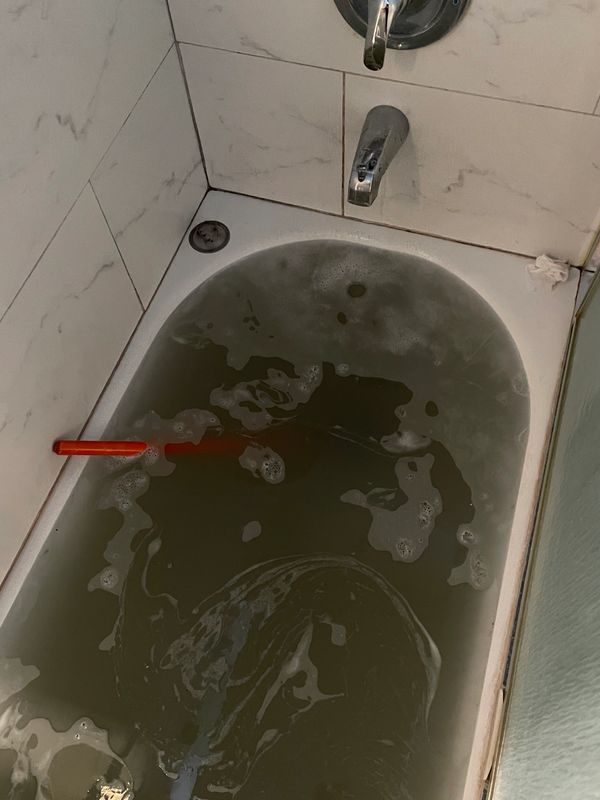 Clogged bathtub in bathroom 