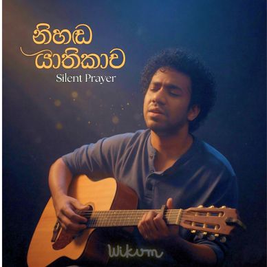 Man playing guitar with eyes closed, titled 'Silent Prayer'.