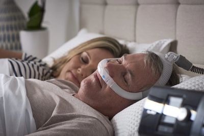 a CPAP patient with a RESMED CPAP machine sleeping with a under the nose sleep cushion 