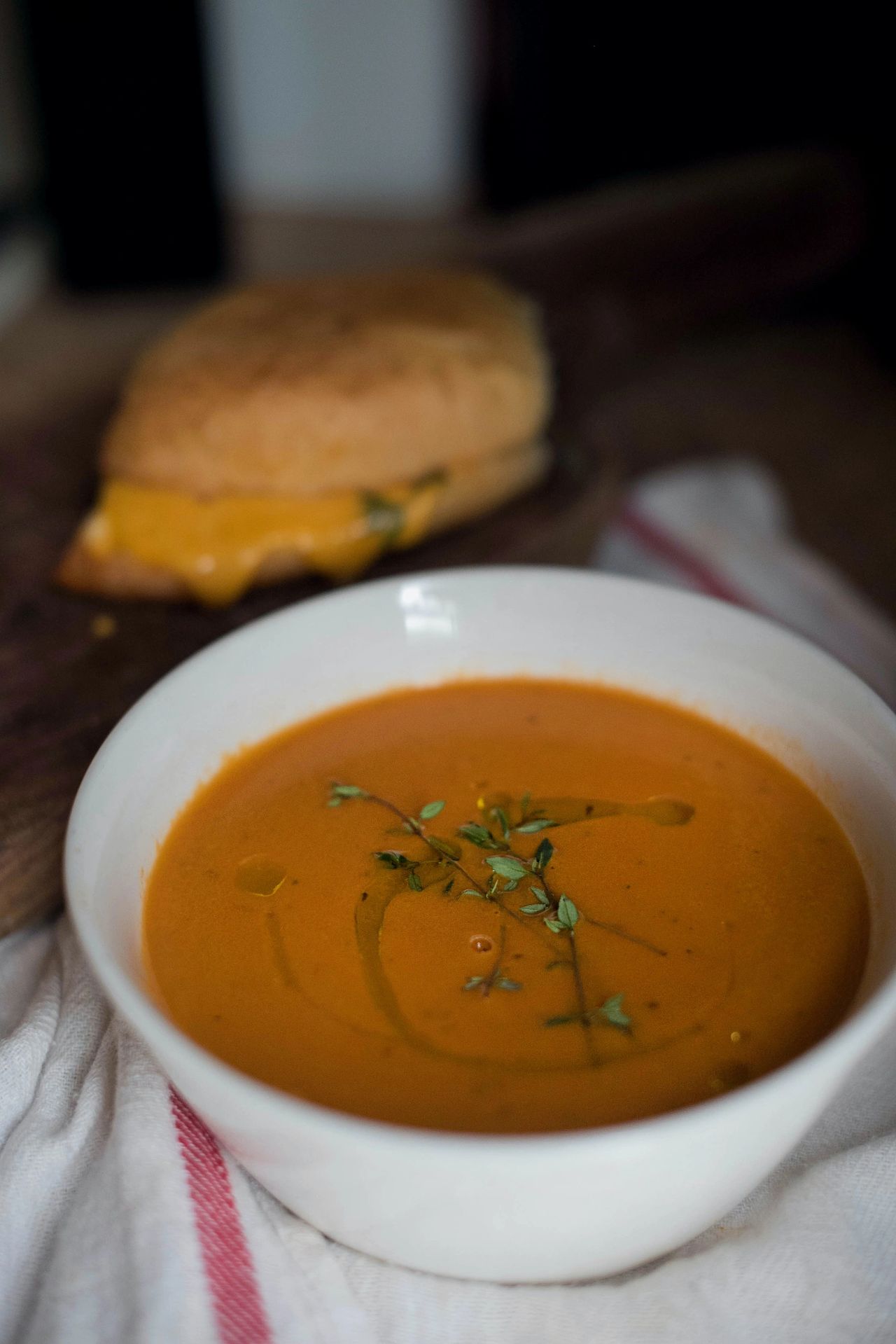 Tomato soup with grilled cheese in the background