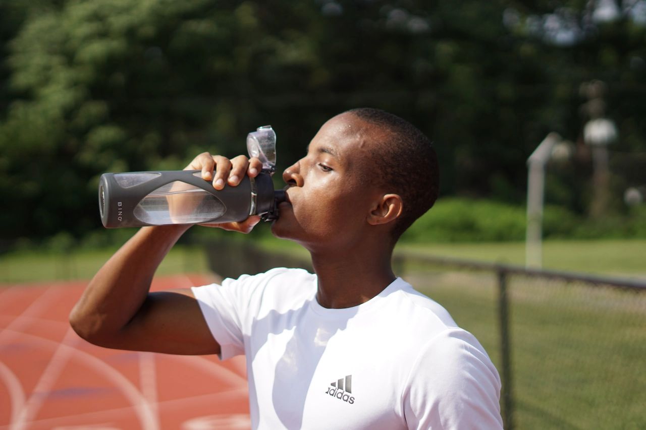 A black young man drinking water
