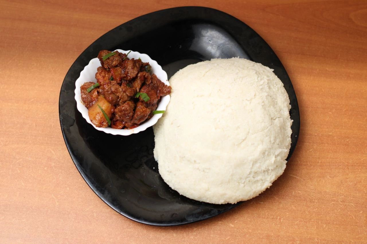 Kenyan Goat Dry Fry, Ugali, Sukuma wiki and Kachumbari. - Ugali - a type of  maize flour porridge that is a staple in many Kenyan househ