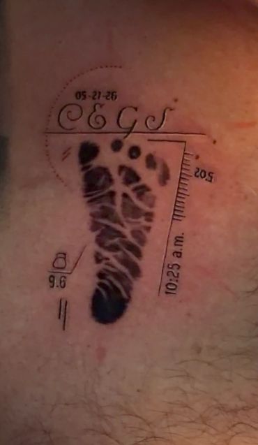 Tattoo of a baby footprint with date and time details.