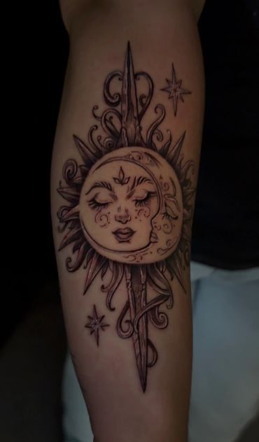 Tattoo of a sun and moon with faces and ornamental details.