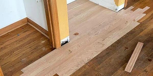 Partially replaced wooden floor with a mix of old and new planks.
