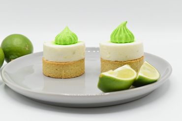 Two Lime Tarts each topped with a Lime Mousse laid side by side