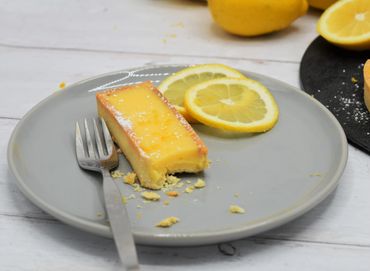 A Lemon Citron tart with a bite taken out of it and a fork laying beside it