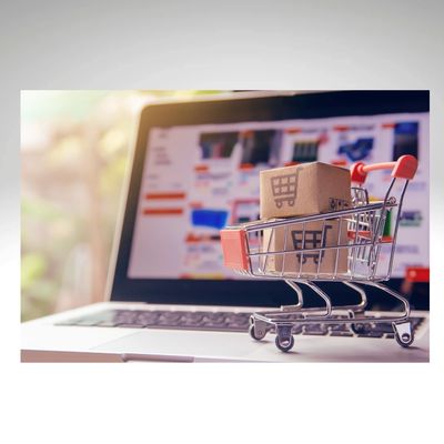 Online selling - supermarket trolley and boxes intront of a laptop  showing selling products online