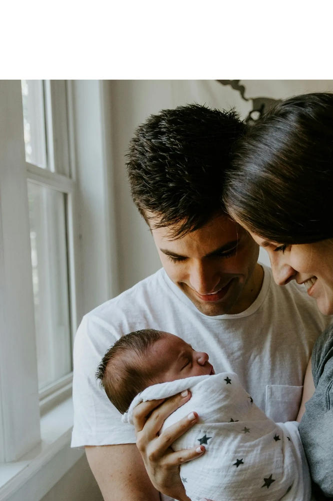 Black pencils in a gray holder next to a stack of white magazines with a camera in the background.