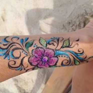 Colorful flower and vine tattoo on forearm.