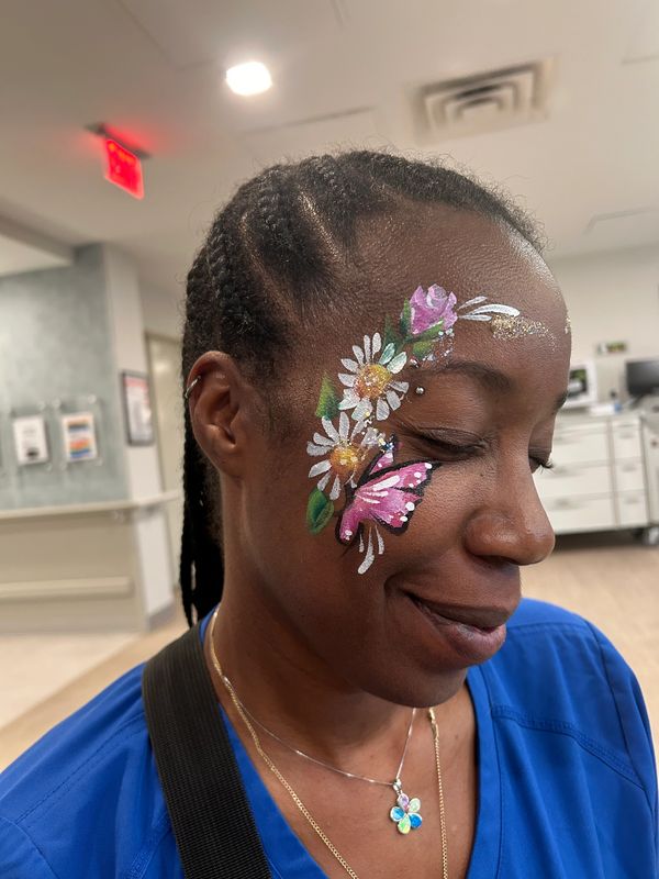 Woman with colorful butterfly and flower face paint.