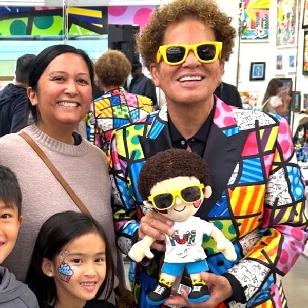Romero Britto with a child I face painted at his store grand opening in Short Hills NJ