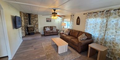 Cozy living room with brown couches and stone fireplace.