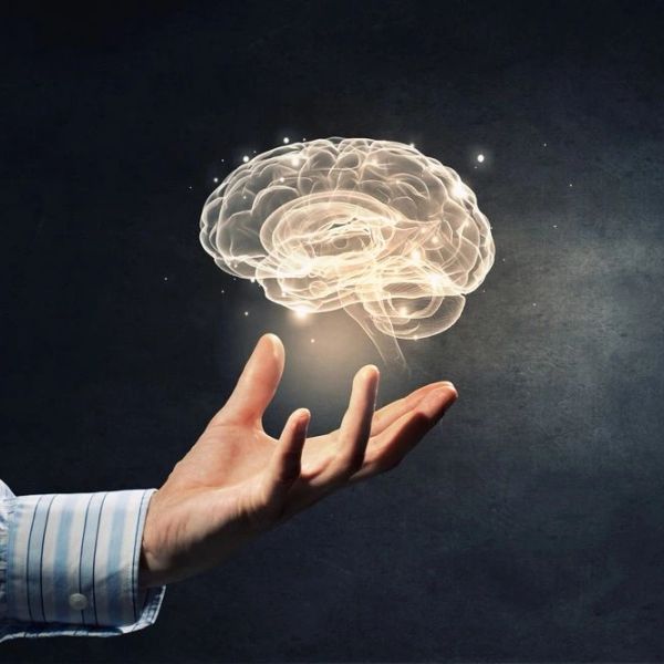 Hand holding a glowing brain hologram.