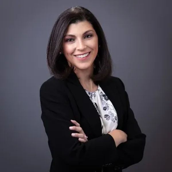 Confident woman smiling with arms crossed.