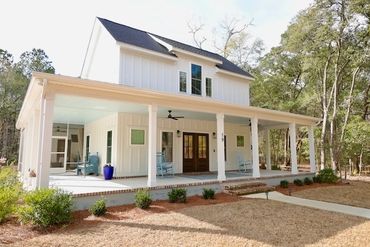 Modern farmhouse with a spacious porch and white siding.