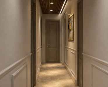A narrow, warmly lit corridor with a closed door at the end.
