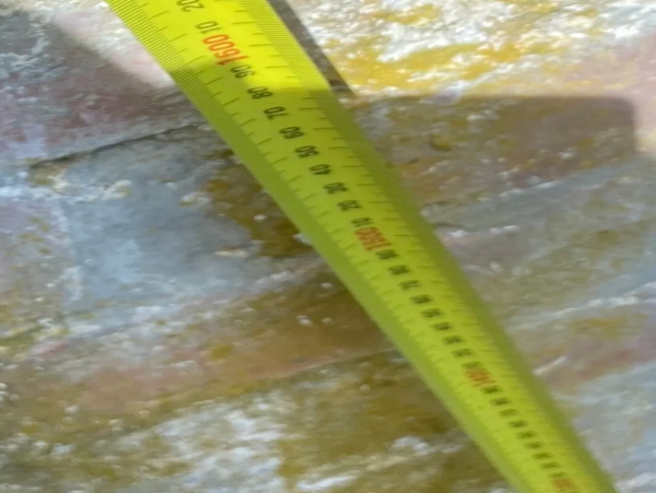 Yellow measuring tape on a textured surface.