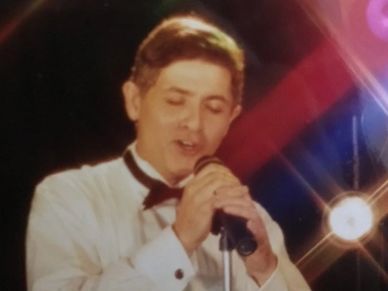 photo jack petrotto singing on stage. eyes closed.