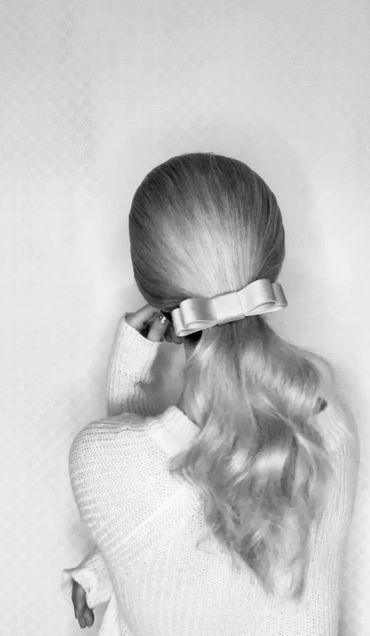 Corduroy bow fitted to a low ponytail for an elegant look
