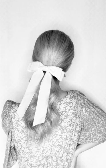 Beige velvet bow fitted to a low ponytail