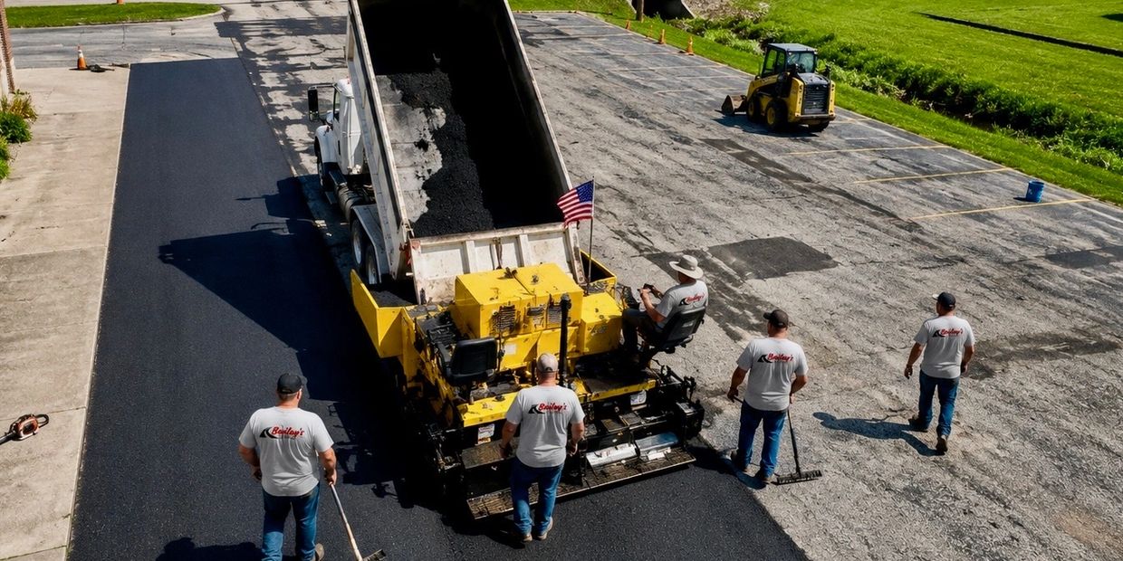 Construction crew paving a parking lot with fresh asphalt.