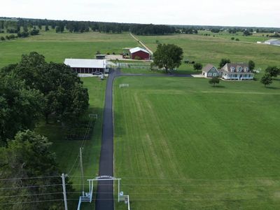 Aerial view of a countryside farm with green fields and buildings.