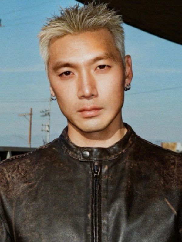 Portrait of a man with platinum blonde hair and a leather jacket.
