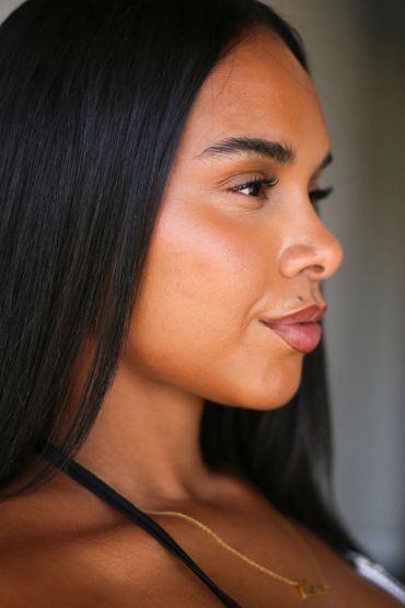 Close-up of a woman with long black hair in profile.